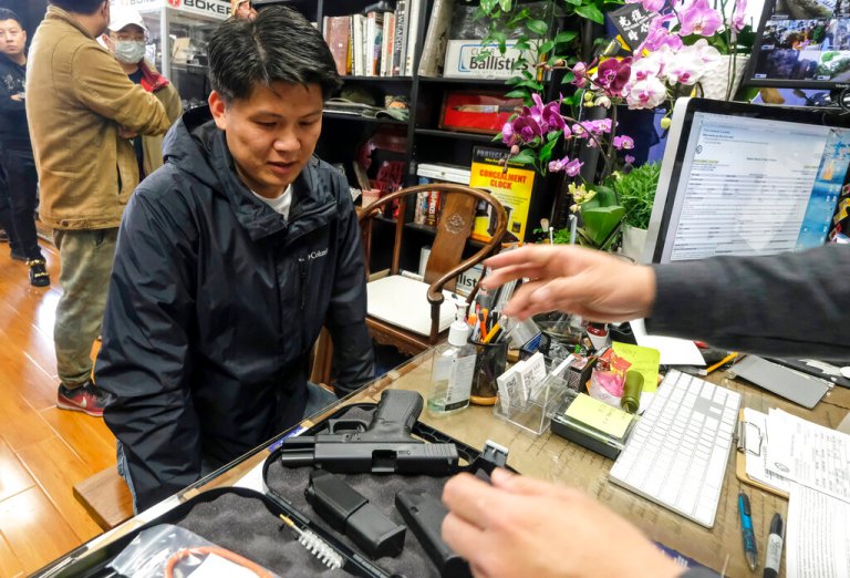 Brian Xia, 44, picks up his gun at a gun store in Arcadia, Calif., on March 15, 2020. A federal appeals court has ruled that California's ban on the sale of semiautomatic weapons to adults under age 21 is unconstitutional. A panel of the 9th U.S. Circuit Court of Appeals said Wednesday, May 11, 2022, that the law violates the 2nd Amendment right to bear arms. (AP Photo/Ringo H.W. Chiu, File)