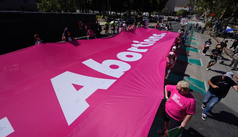 Abortion-rights demonstrators carry a giant banner during a rally at Los Angeles City Hall, Saturday, May 14, 2022. 