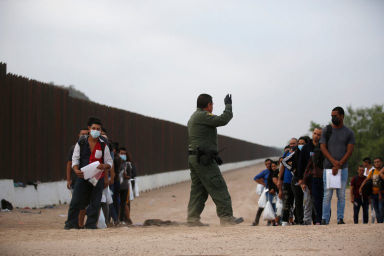 A Border Patrol agent instructs migrants who had crossed the Rio Grande river into the U.S. in Eagle Pass, Texas, Friday, May 20, 2022. 
