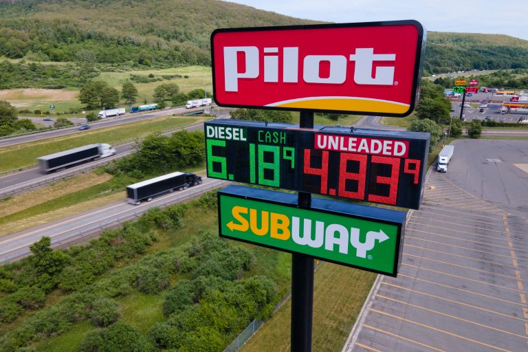 Trucks and cars drive by a Pilot Travel Center sign displaying fuel prices in Bath, New York, on Monday, June 20, 2022. The owners of a small New York farm, Lloyd Crest, had almost 800 gallons of diesel gasoline stolen from them in June. (AP Photo/Ted Shaffrey)