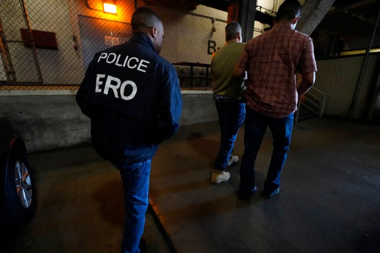 U.S. Immigration and Customs Enforcement agents transfer an immigrant into the ICE Metropolitan Detention Center in Los Angeles after an early morning raid on June 6, 2022.