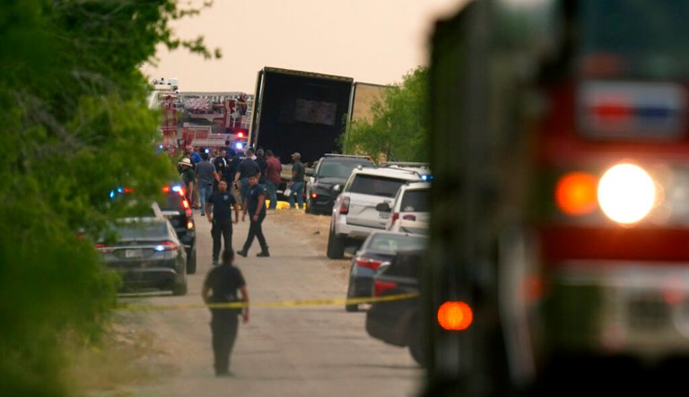 Body bags lie at the scene where a tractor-trailer with multiple dead bodies was discovered in San Antonio.
