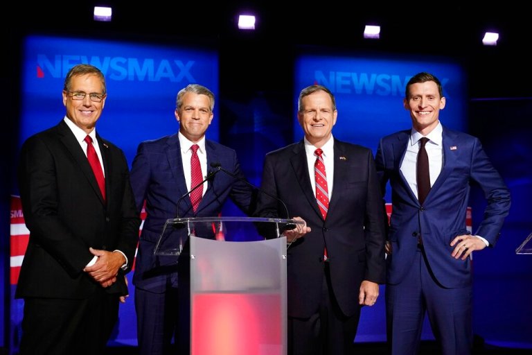 Arizona Republican U.S. Senate candidates Jim Lamon, left, Mick McGuire, second from right, and Blake Masters, right, pose for a photograph with moderator John Bachman, second from left, prior to the Arizona Republican Senate primary debate hosted by Newsmax, July 13, 2022. (AP Photo/Ross D. Franklin)