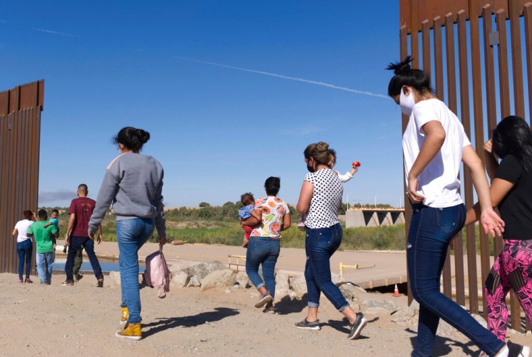 A group of Brazilian migrants make their way around a gap in the U.S.-Mexico border in Yuma, Arizona, seeking asylum in the U.S. after crossing over from Mexico, June 8, 2021.
