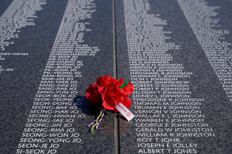 A bouquet rests on a section of the Korean War Veterans Memorial's newly unveiled Wall of Remembrance, Wednesday, July 27, 2022, in Washington. 