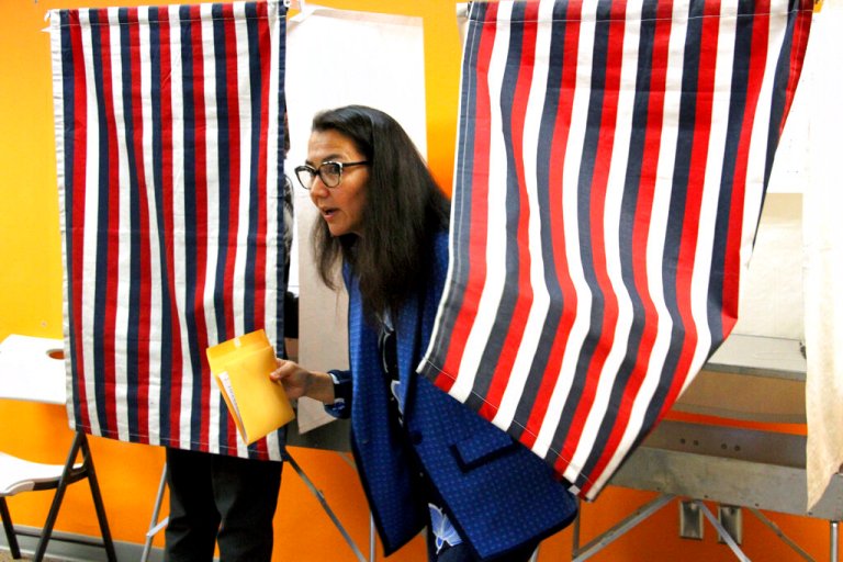 Mary Peltola is shown leaving a voting booth while early voting on Aug. 12, 2022, in Anchorage, Alaska.