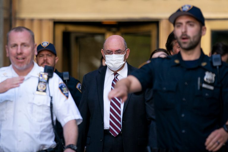 Law enforcement personnel escort the Trump Organization's former Chief Financial Officer Allen Weisselberg (center) as he departs the court on Friday in New York.