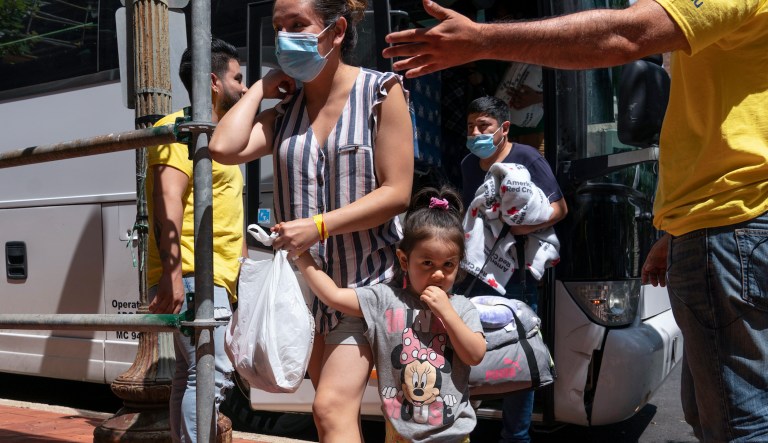 Silvia Moreno del Castillo, center, of Lima, Peru, holds her daughter Brisa, 3, by the hand, followed by her husband Gerardo Puente, as the family who is seeking asylum from Peru is greeted by Derick Alegria, left, and Orlando Andara, both with the nonprofit SAMU First Response, as a bus of asylum seekers who were sent from Arizona to Washington arrives, Thursday, Aug. 11, 2022, to a church on Capitol Hill in Washington. Moreno del Castillo had an allergic reaction on her feet and ankles while making her way to the United States and was able to receive medical care on the bus. As her court date will be in New York, she was relieved to have a safe and free passage to the East Coast from Arizona.