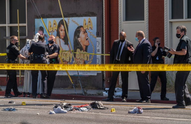 A photographer with the Los Angeles Police Department, far right, documents the remains of a crime scene in Beverly Hills, Calif.