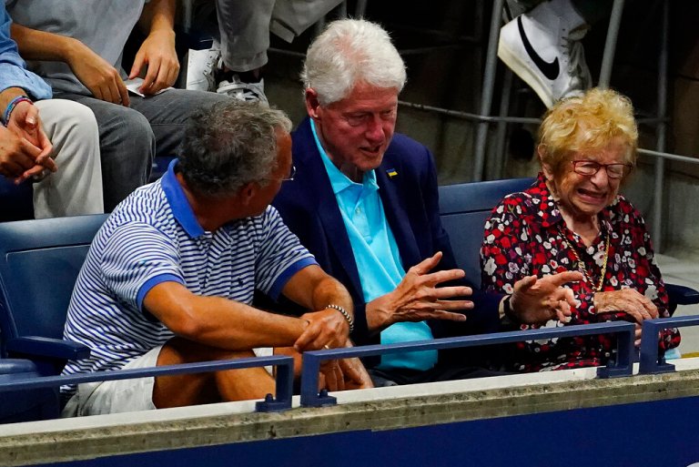 Former President Bill Clinton, center, and Ruth Westheimer, right, watch play between Serena Williams, of the United States, and Danka Kovinic, of Montenegro, during the first round of the US Open tennis championships, Monday, Aug. 29, 2022, in New York. 