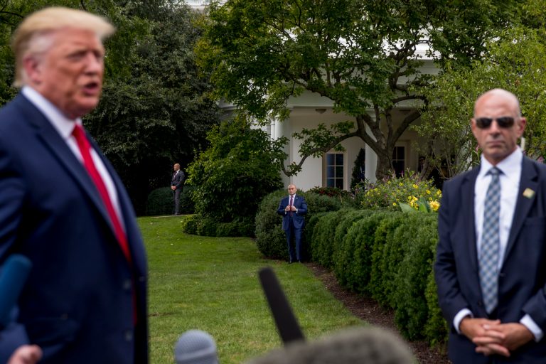 Members of the Secret Service, including Tony Ornato, right, stand guard as then-President Donald Trump, left, speaks to reporters on the South Lawn.