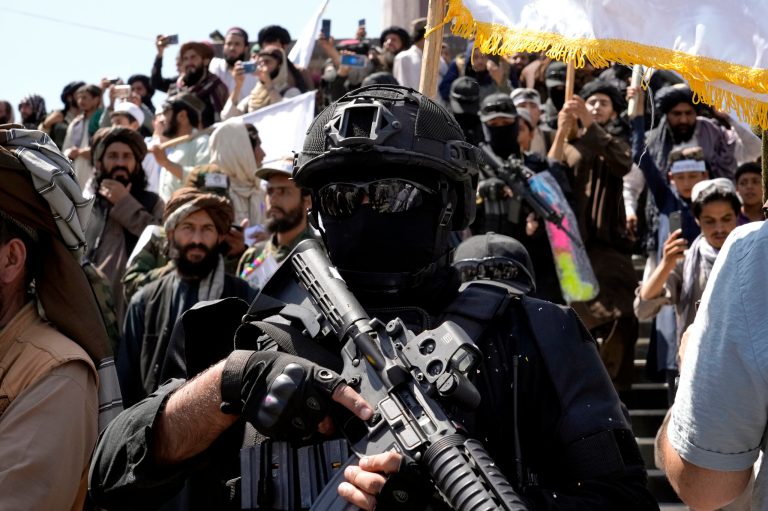A Taliban fighter walks with supporters during a celebration of the first anniversary of the withdrawal of US-led troops from Afghanistan, in front of the U.S. Embassy in Kabul, Afghanistan, on Aug. 31.