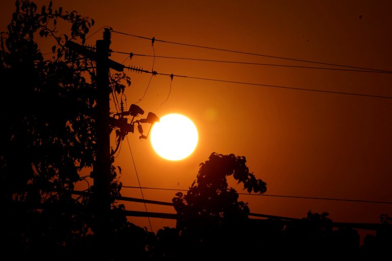 Sunrise is viewed between power lines in Sacramento, California, on Sept. 8. The record-breaking heat that has pushed the state's electrical grid to the brink of power outages for more than a week.