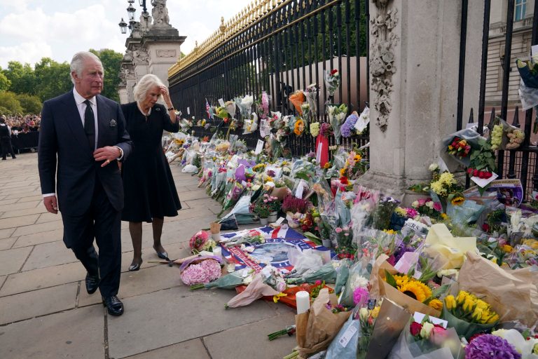 Britain's King Charles III, left, and Camilla, the Queen Consort, look at floral tributes left outside Buckingham Palace following Thursday's death of Queen Elizabeth II in London on Sept. 9, 2022.