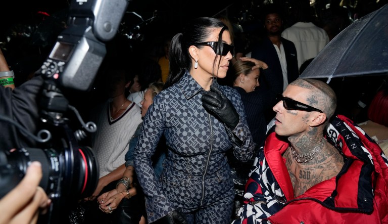 Kourtney Kardashian, left, and Travis Barker attend the Tommy Hilfiger Fall 2022 fashion show at the Skyline Drive-In on Sunday, Sept. 11, 2022, in New York.