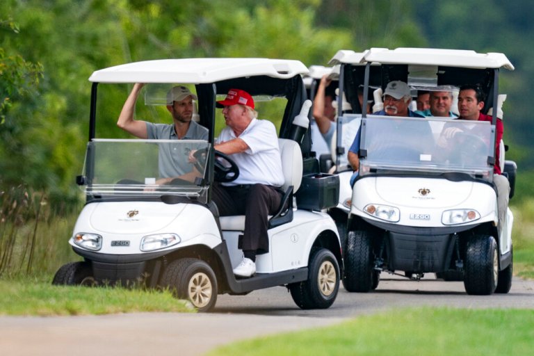 Former President Donald Trump drives a cart at Trump National Golf Club with his son Eric Trump at left, on Sept. 12, 2022, in Sterling, Virginia.
