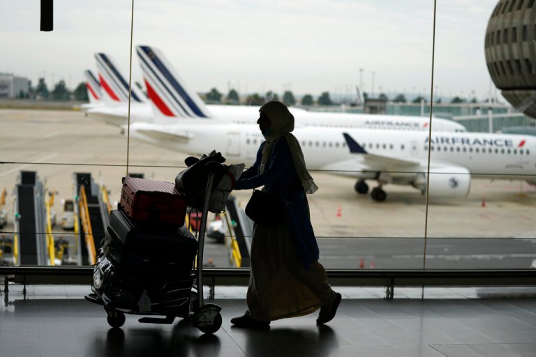 A traveler pulls her trolley Friday, Sept. 16, 2022 at Roissy Charles de Gaulle airport, north of Paris. Many domestic and some international flights were canceled in France Friday as air traffic controllers went on a national strike over pay and recruitment issues. French civil aviation authority DGAC warned that domestic traffic would be 