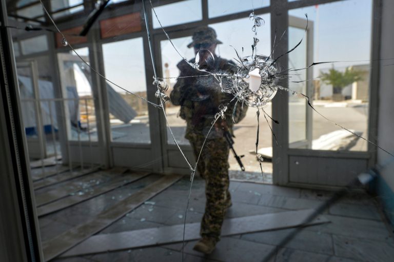 A Kyrgyz soldier enters a checkpoint damaged after fighting on the border between Kyrgyzstan and Tajikistan, in the vilage of Kyzyl-Bel village 950 km (593 miles) southeast of Bishkek, Kyrgyzstan, Monday, Sept. 19, 2022. Fighting started last Wednesday, for no obvious or publicly announced reason. The outbreak of fighting has killed about 100 on both sides.