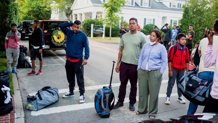 Immigrants who arrived on a flight sent by Florida Gov. Ron DeSantis gather with their belongings outside St. Andrews Episcopal Church in Martha's Vineyard, Massachusetts.