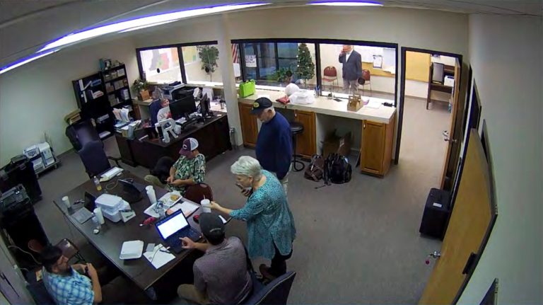 In this Jan. 7, 2021, image taken from Coffee County, Ga., security video, Cathy Latham (center) is seen in the local elections office in Douglas, Ga., while a computer forensics team was there to make copies of voting equipment.
