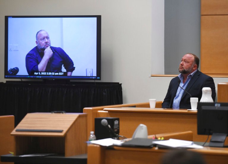 Infowars founder Alex Jones is shown a clip of his former deposition while testifying in the Sandy Hook defamation damages trial at Connecticut Superior Court in Waterbury, Connecticut, on Sept. 22, 2022.