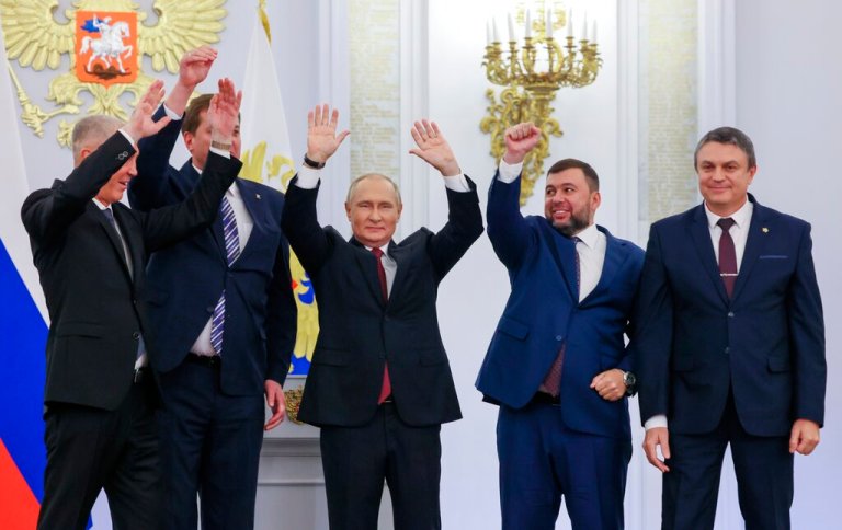 From left, Moscow-appointed head of Kherson Region Vladimir Saldo, Moscow-appointed head of Zaporizhzhia region Yevgeny Balitsky, Russian President Vladimir Putin, center, Denis Pushilin, the leader of the Donetsk People's Republic and Leonid Pasechnik, leader of self-proclaimed Luhansk People's Republic wave during a ceremony to sign the treaties for four regions of Ukraine to join Russia, at the Kremlin in Moscow, Friday, Sept. 30, 2022. The signing of the treaties making the four regions part of Russia follows the completion of the Kremlin-orchestrated 