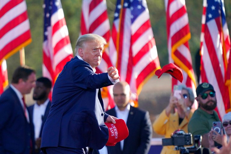Former President Donald Trump throws hats to supporters at a rally, Sunday, Oct. 9, 2022, in Mesa, Arizona.