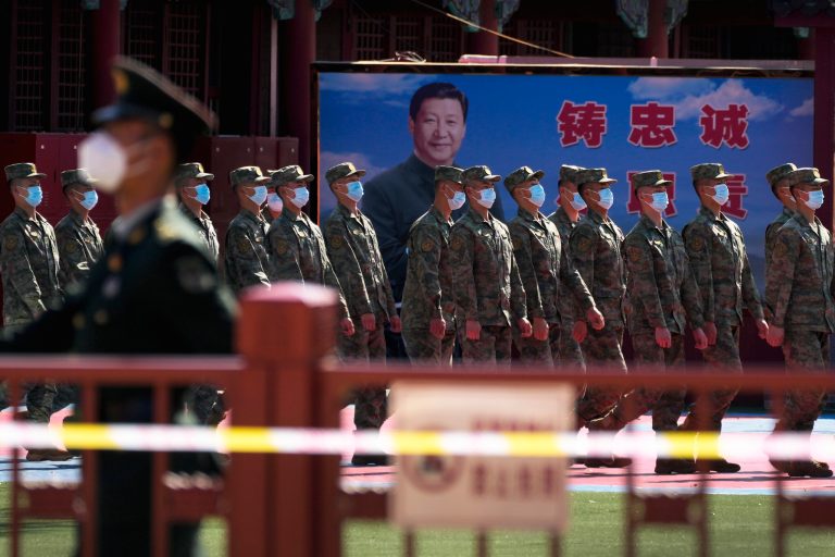 People's Liberation Army (PLA) soldiers march past a poster depicting Chinese President Xi Jinping at their quarters during the opening ceremony of the 20th National Congress of China's ruling Communist Party in Beijing, China, Sunday, Oct. 16, 2022. China on Sunday opens a twice-a-decade party conference at which leader Xi Jinping is expected to receive a third five-year term that breaks with recent precedent and establishes himself as arguably the most powerful Chinese politician since Mao Zedong. 