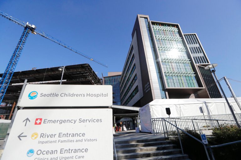 A sign stands outside Seattle Children's Hospital on March 18, 2020, in Seattle. Children's hospitals in parts of the country are seeing a distressing surge in RSV, a common respiratory illness that can cause severe breathing problems for babies. 