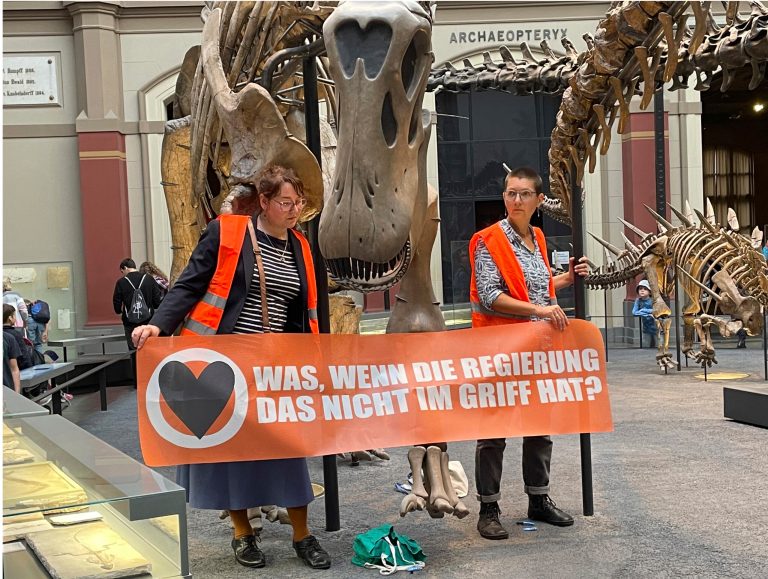 Two climate activists carrying a banner 