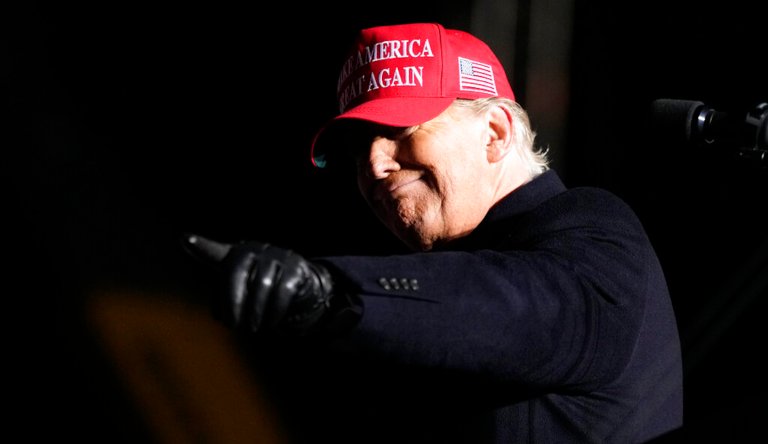 Former President Donald Trump reacts to a supporter during a rally in Sioux City, Iowa.