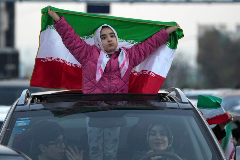 An Iranian girl holds up her country's flag during a street celebration after Iran's national soccer team defeated Wales in Qatar's World Cup, at Sadeghieh Sq. in Tehran, Iran, Nov. 25, 2022. 