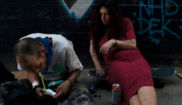 Jenn Bennett, who is high on fentanyl, sits on her skateboard with a visible black eye as her friend, Jesse Williams, smokes the drug in Los Angeles on Aug. 9, 2022. Use of fentanyl, a synthetic opioid that is 50 times more potent than heroin, has exploded. Even a small dose can be fatal, and it has quickly become the deadliest drug in the nation, according to the Drug Enforcement Administration. 