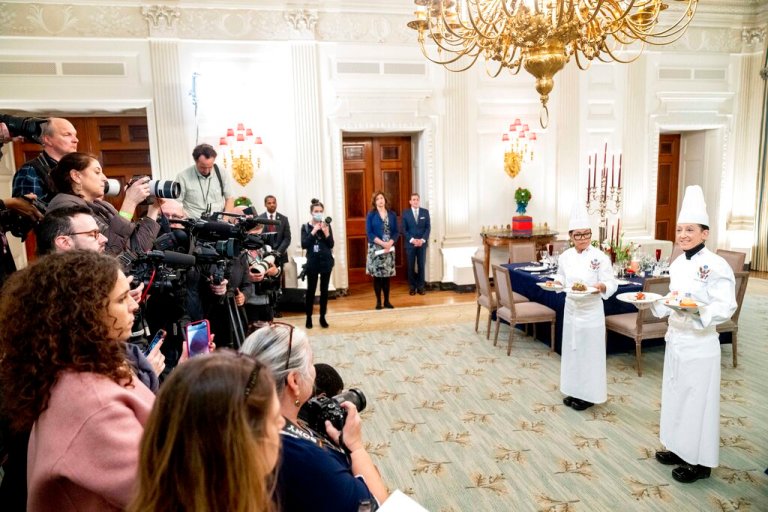 White House executive chef Cris Comerford, left, and White House executive pastry chef Susie Morrison, right, hold dishes during a media preview for the State Dinner with President Joe Biden and French President Emmanuel Macron in the State Dining Room of the White House in Washington, Wednesday, Nov. 30, 2022.