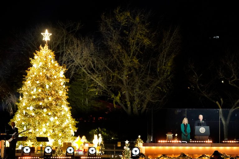 President Joe Biden speaks as first lady Jill Biden listens during the National Christmas Tree lighting ceremony on the Ellipse, near the White House in Washington, Wednesday, Nov. 30, 2022.