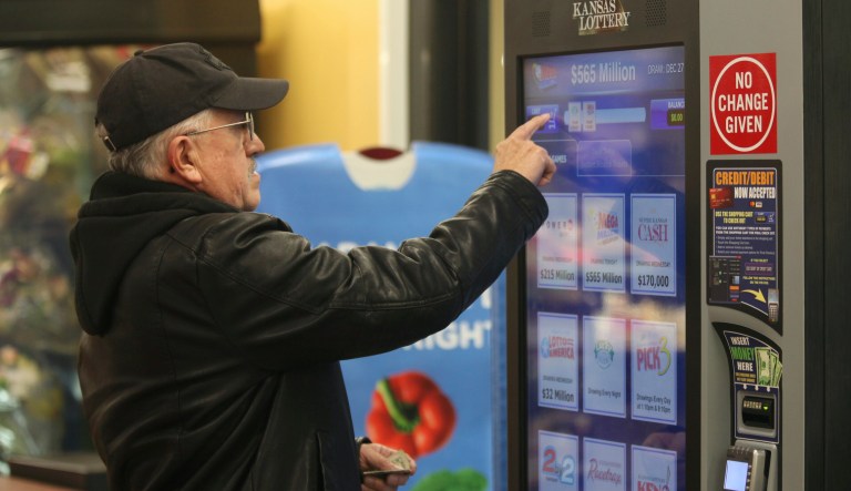 David Peralta, a 67-year-old retired technical college instructor, buys a Mega Millions ticket at a Kansas Lottery machine in a Dillons grocery, Tuesday, Dec. 27, 2022, in Topeka, Kan.
