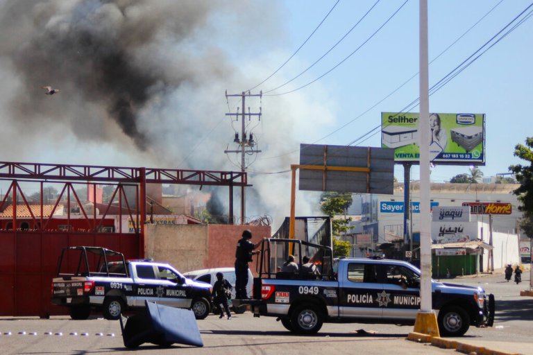 The police arrives on the scene after a store was looted in Culiacan, Sinaloa state, Thursday, Jan. 5.