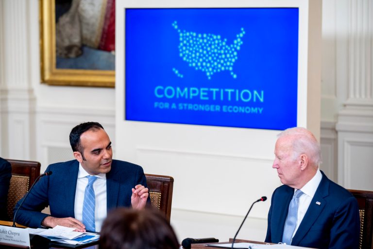 Consumer Financial Protection Bureau Director Rohit Chopra, left, accompanied by President Joe Biden, right, speaks at a meeting with his Competition Council on the economy and prices in the East Room of the White House in Washington, Wednesday, Feb. 1, 2023.