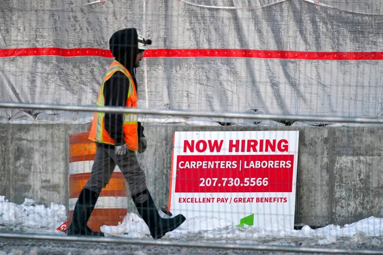 A worker passes a hiring sign at a construction site, Wednesday, Jan. 25, 2023, in Portland, Maine. On Thursday, the Labor Department reports on the number of people who applied for unemployment benefits last week. 