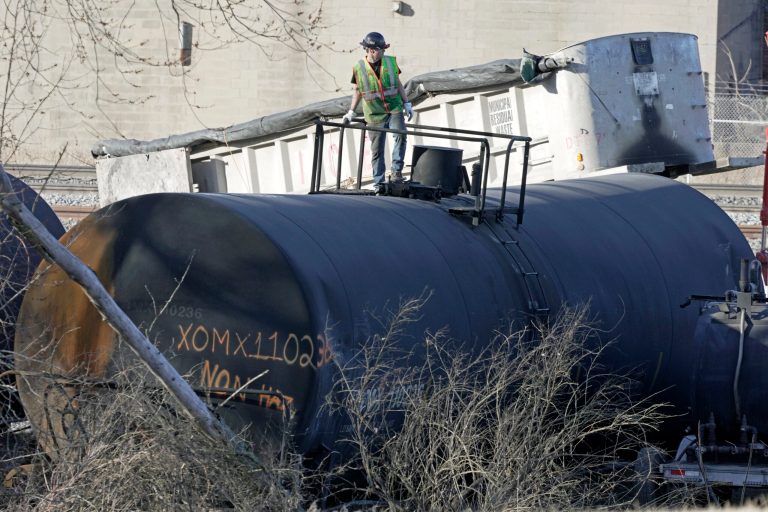A cleanup worker stands on a derailed tank car as the cleanup of portions of a Norfolk Southern freight train that derailed over a week ago in East Palestine, Ohio, continues, Wednesday, Feb. 15, 2023. 