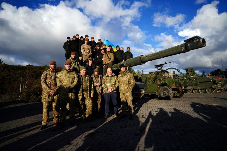 Britain's Defense Secretary Ben Wallace, second right, bottom, posed with Ukrainian soldiers during a visit at Bovington Camp, a British Army military base where they were training on Challenger 2 tanks, in Dorset, England, Wednesday Feb. 22, 2023. 