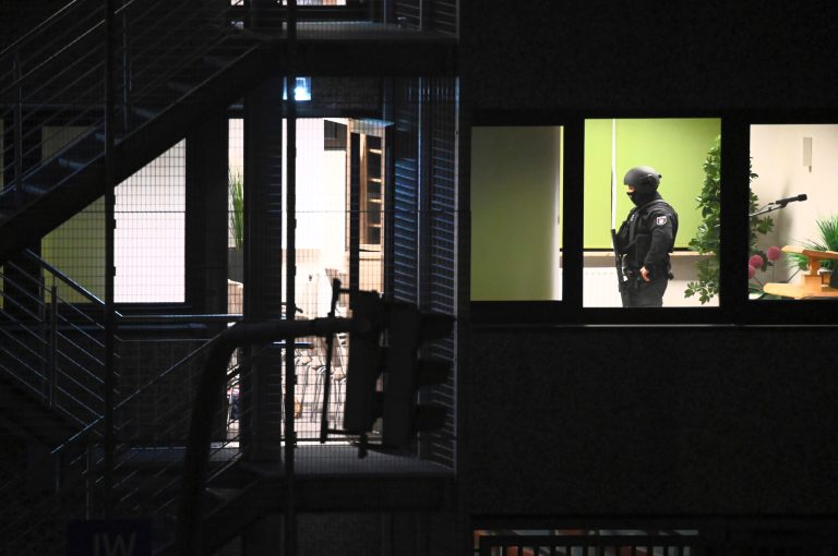 Police officers in special equipment walk through a Jehovah's Witness building in Hamburg, Germany, Thursday, March 9, 2023. German police say shots were fired inside a building used by Jehovahâs Witnesses in Hamburg and an unspecified number of people were killed or wounded.
