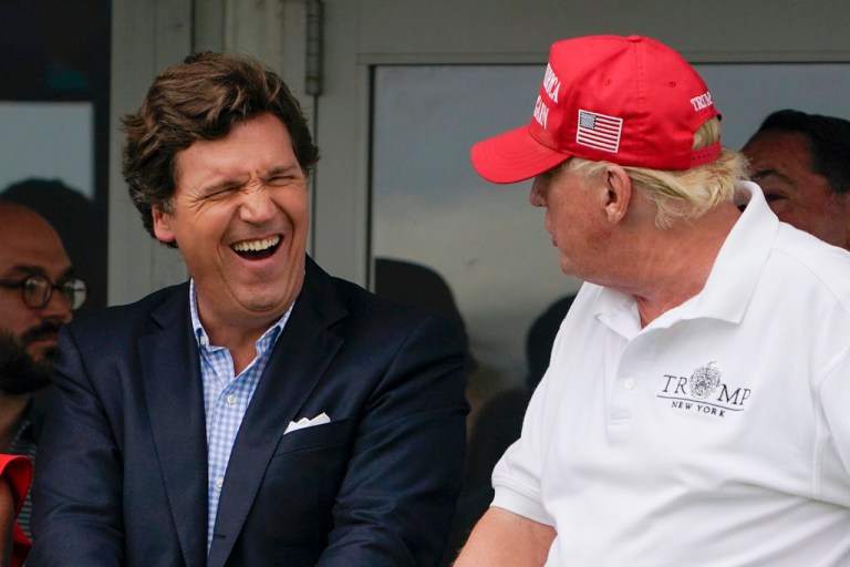 FILE - Tucker Carlson, left, and former President Donald Trump, right, react during the final round of the Bedminster Invitational LIV Golf tournament in Bedminster, N.J., July 31, 2022. Trump bypassed the first 2023 presidential debate in favor of an interview with Carlson. (AP Photo/Seth Wenig, File)