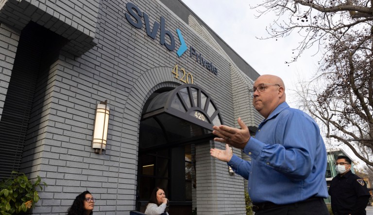 Complex Financial Institution Resolution Specialist Brian J. Teitel speaks with customers waiting in line outside of a Silicon Valley Bank in Palo Alto, Calif., on Monday, March 13, 2023. The federal government intervened Sunday to secure funds for depositors to withdraw from Silicon Valley Bank after the banks collapse. Several individuals waited in line before the bank opened to withdraw funds. 