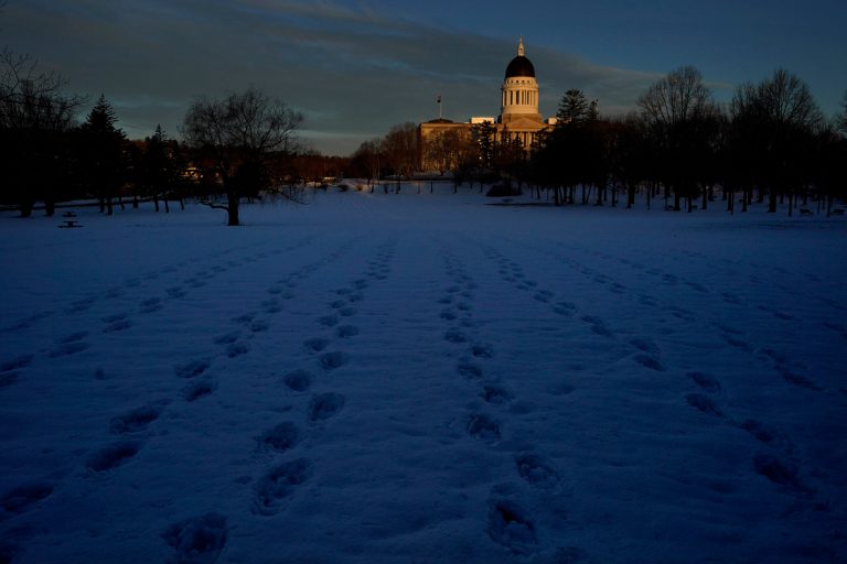Frozen snowshoe tracks cross the landscape at Capitol Park at at the State House during the final week of winter, Thursday, March 16, 2023, in Augusta, Maine. (AP Photo/Robert F. Bukaty)