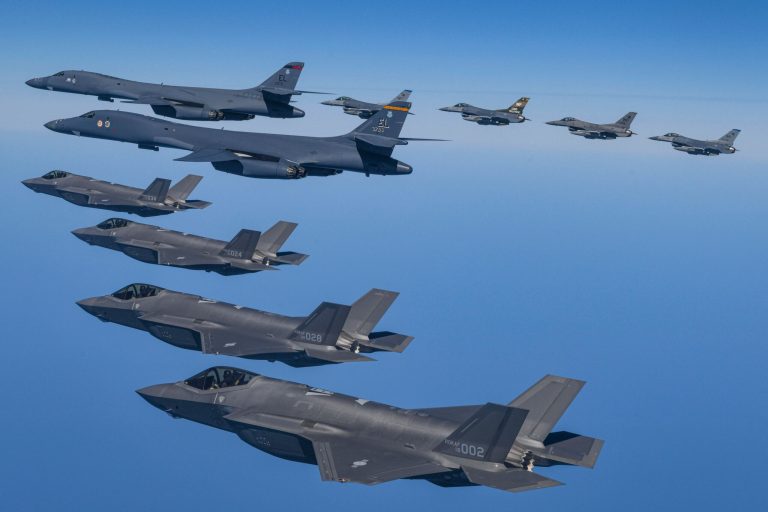 In this photo provided by South Korea Defense Ministry, U.S. Air Force B-1B bombers, top center, fly in formation with South Korea's Air Force F-35A fighter jets and U.S. Air Force F-16 fighter jets, top right, over the South Korea Peninsula during a joint air drill in South Korea, Sunday, March 19, 2023.