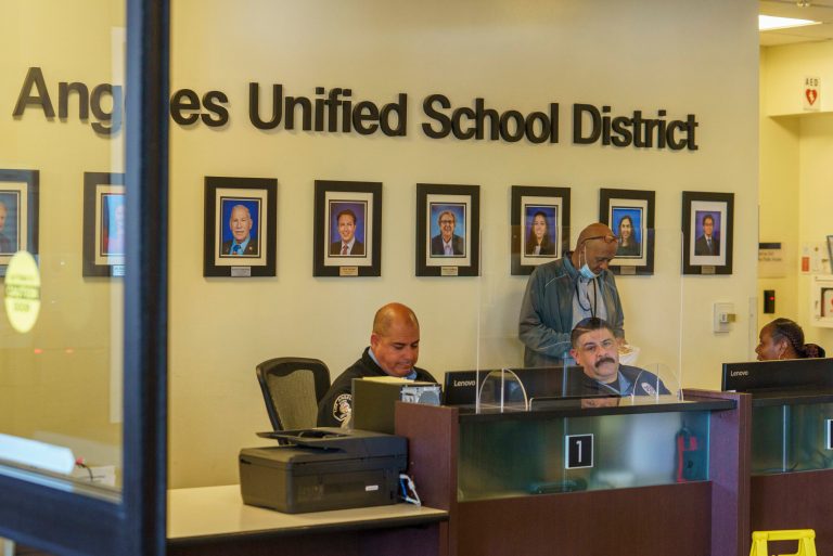 Security officers staff the front desk under portraits of board members of the Los Angeles Unified School District headquarters as thousands of teachers and Service Employees International Union 99 members rally outside the LAUSD headquarters in Los Angeles Tuesday, March 21, 2023. Tens of thousands of workers in the LAUSD walked off the job Tuesday over stalled contract talks, and they were joined by teachers in a three-day strike that shut down the nation's second-largest school system.