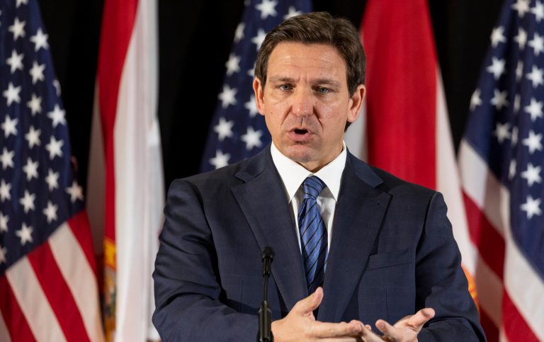 Florida Gov. Ron DeSantis answers questions from the media during a press conference at Christopher Columbus High School on Monday, March 27, 2023, in Miami. The press conference was held to announce DeSantis's signing of a private school voucher expansion, HB1, which allows more Florida school children become eligible for taxpayer-funded school vouchers.