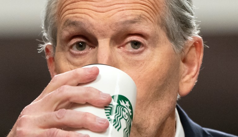 Former Starbucks CEO Howard Schultz drinks from a Starbucks mug as he testifies before the Senate Health, Education, Labor, and Pensions committee, Wednesday, March 29, 2023, on Capitol Hill in Washington.