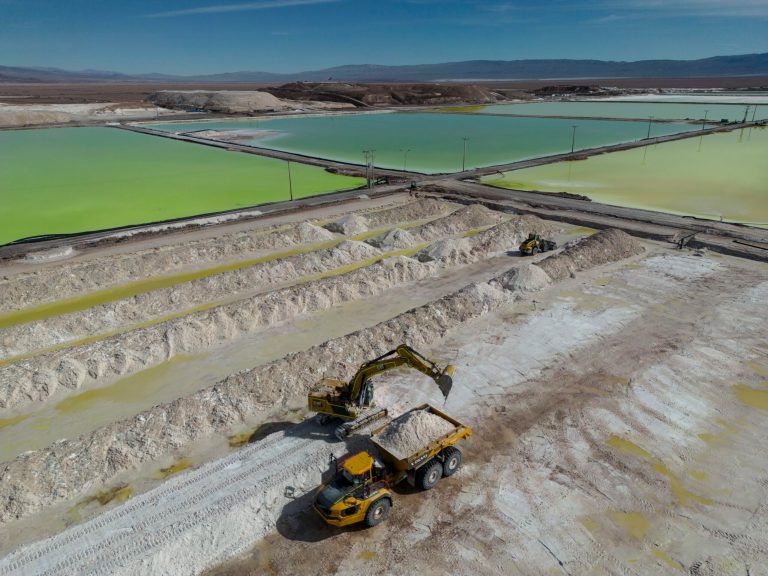 An excavator scoops lithium-packed salt into a dump truck at the SQM mine in the Atacama desert in Chile, April 2023. Chinese EV maker BYD announced a $290 million investment build a lithium cathode processing factory in the country, giving it more strategic access to Chile's lithium reserves. (AP/Rodrigo Abd)